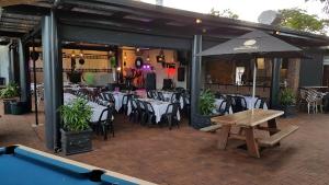 un ristorante con tavoli, sedie e tavolo da biliardo di Gin Gin Budget Accommodation a Gin Gin