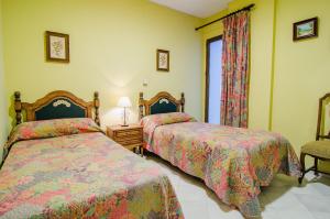 sypialnia z 2 łóżkami i oknem w obiekcie Apartamentos Salmerones w mieście Alhama de Granada