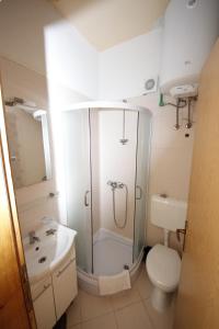 a bathroom with a shower and a toilet and a sink at Apartmani Znaor in Baška Voda +37 photos