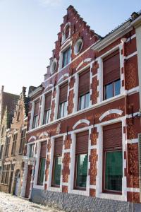an old brick building with windows on a street at Huis Sint-Andriescruyse in Bruges