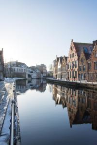 een rivier in een stad met huizen en gebouwen bij Huis Sint-Andriescruyse in Brugge