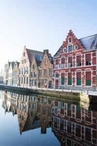 een groep gebouwen naast een rivier bij Huis Sint-Andriescruyse in Brugge