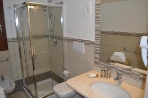 a bathroom with a shower and a sink and a toilet at Guest Rooms Affittacamere in San Teodoro