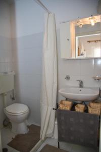 a bathroom with a white toilet and a sink at Corfu Retreat in Corfu