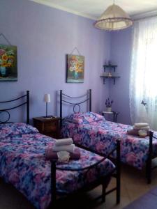 two beds in a bedroom with purple walls at Il Tempietto di Venere in Tivoli