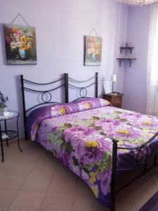 a bedroom with a bed with a purple comforter at Il Tempietto di Venere in Tivoli