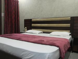 哈尔德瓦尼Hotel Silk的卧室里有一张大床，床边挂着红色的窗帘 更多28张照片