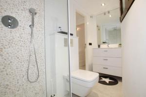 a white bathroom with a toilet and a shower at Primera Linea de Playa in Moraira