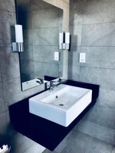 Nilaveli Ocean Condos في ترينكومالي: حمام مع حوض أبيض ومرآة