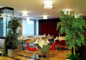 ein Restaurant mit Tischen, Stühlen und Pflanzen in der Unterkunft Demora Hotel in Ankara