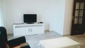 una sala de estar con TV de pantalla plana en un armario blanco en Residencial Torre Bermeja, en Estepona