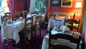 ein Esszimmer mit Tischen und weißen Tischdecken in der Unterkunft A-Haven Townhouse Hotel in Edinburgh