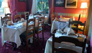 un comedor con mesas con manteles blancos en A-Haven Townhouse Hotel, en Edimburgo 51 fotos más