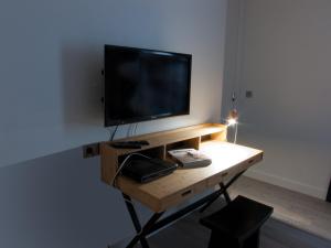 a television sitting on a table in a room at La Maison de Léa in Paris