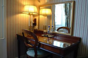 a dining room table with a lamp and a mirror at A-Haven Townhouse Hotel in Edinburgh