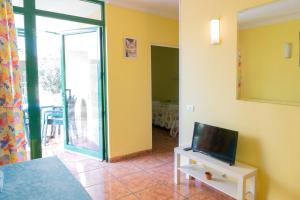 a living room with a tv on a white table at Apartamento Pepe in Playa del Ingles