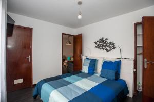 sypialnia z łóżkiem z niebieską i białą pościelą w obiekcie RENTY Côté Parc Parking inclus w Marsylii