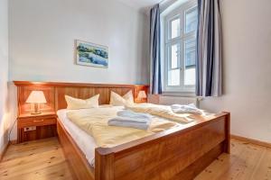 アールベックにあるVilla Ahlbeck - Ferienwohnung Kühlungsbornのベッドルーム1室(木製ベッド1台、窓付)
