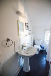 a white bathroom with a sink and a toilet at Eastbourne Reymar in Eastbourne