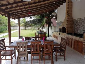 a dining room with a table and chairs and a fireplace at Casa Maravilhosa Unamar Verão Vermelho Cabo Frio in Tamoios