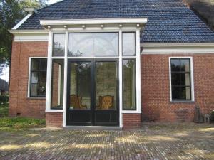 ザイドラーレンにあるB&B In het Voorhuysの大きなガラス戸のある家