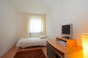 ein kleines Schlafzimmer mit einem Bett und einem TV in der Unterkunft ProFair Apartments - room agency in Hannover