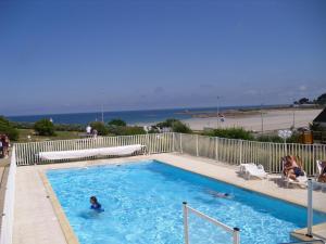 una piscina con gente en ella con la playa en Les Terrasses de la plage de Trestel, en Trévou-Tréguignec