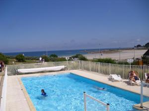 Trévou-TréguignecにあるLes Terrasses de la plage de Trestelのビーチ沿いのスイミングプール