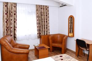 a room with a bed and a desk and a chair at Hotel Select in Tulcea