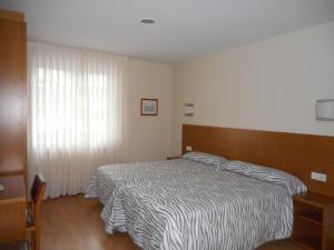 a hotel room with a bed and a window at Pension Restaurante La Bombilla in A Estrada