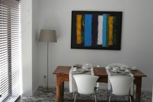 a dining room table with white chairs and a painting at Les terres in Chaponost
