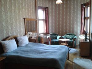 ein Schlafzimmer mit einem Bett und zwei Stühlen darin in der Unterkunft Rezydencja Janków in Iłowa