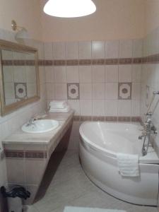 Iłowa的住宿－瑞扎德加簡克酒店，带浴缸、水槽和镜子的浴室