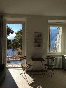 Zimmer mit 2 Stühlen, einem Tisch und einem Fenster in der Unterkunft Sonny apartments in Malcesine
