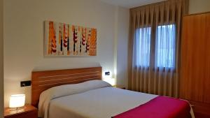 Un dormitorio con una cama y una ventana. en Apartamentos Puerta Muralla, en Teruel