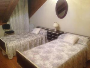 two beds in a bedroom with a mirror and a dresser at Fuensaldaña Turística in Fuensaldaña