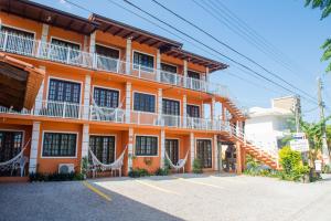 Un bâtiment orange avec des hamacs se trouve en face de l'établissement. dans l'établissement Residencial Maria Antonia, à Florianópolis