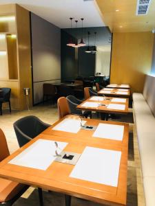 eine Reihe von Tischen und Stühlen in einem Restaurant in der Unterkunft Borrman International Hotel Canton Tower Chigang Metro Station Flagship Branch in Guangzhou + 38 Fotos