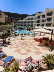 a couple of people laying in lawn chairs in a pool at Cefalù Sea Palace in Cefalù