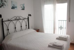 a bedroom with a white bed with two towels on it at Easy Nerja Apartments in Nerja +102 photos