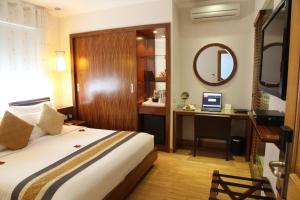 1 dormitorio con 1 cama y escritorio con ordenador en Elite Central Hotel Hanoi, en Hanói