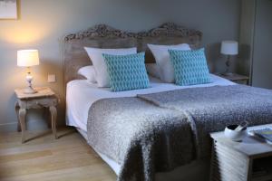 a bedroom with a large bed with blue and white pillows at EVIDENCE Maison d'Hôtes in Mercurey