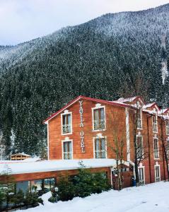 فندق يايلا في أوزونغول: مبنى في الثلج امام جبل