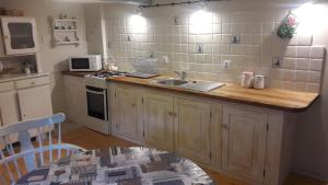 una cucina con piano di lavoro, lavandino e piano cottura di Wsiowa Chata a Ścinawka Górna Altre 12 foto