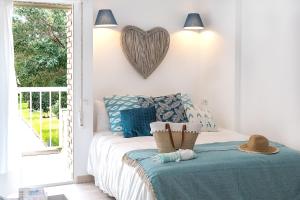 ベナルマデナにあるCozy Flat Simona Costa del Solのベッドルーム1室(壁にハートを配置したベッド1台付)