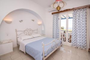 una camera bianca con un letto e una finestra di Albatross Holiday Apartments a Agios Sostis
