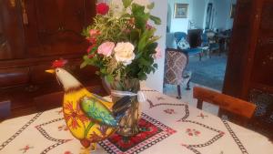 a table with a vase of flowers and a chicken on it at Kleineweide Boutique Estate in Pretoria