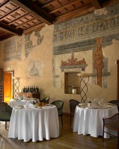 a dining room with two tables with white table cloth at Hotel Locanda Dei Mai Intees in Azzate