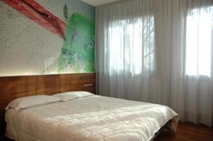 カオルレにあるAlloggi Taverna Caorlinaのベッドルーム1室(ベッド1台付)が備わります。壁には絵画が飾られています。