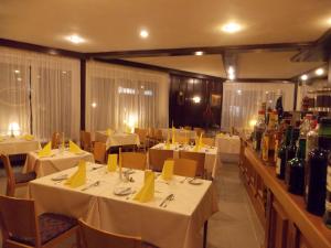 a restaurant with white tables and bottles of wine at Hotel Krone in Bad Münster am Stein-Ebernburg